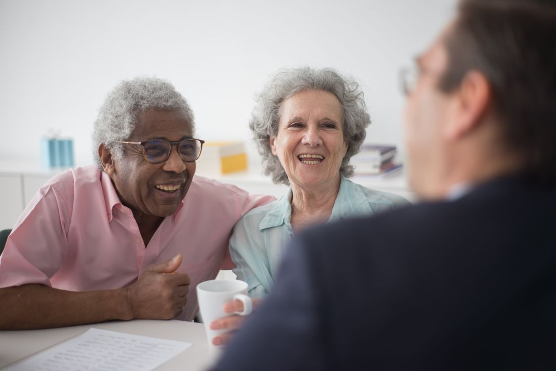 An older couple meeting with their advisor at a table